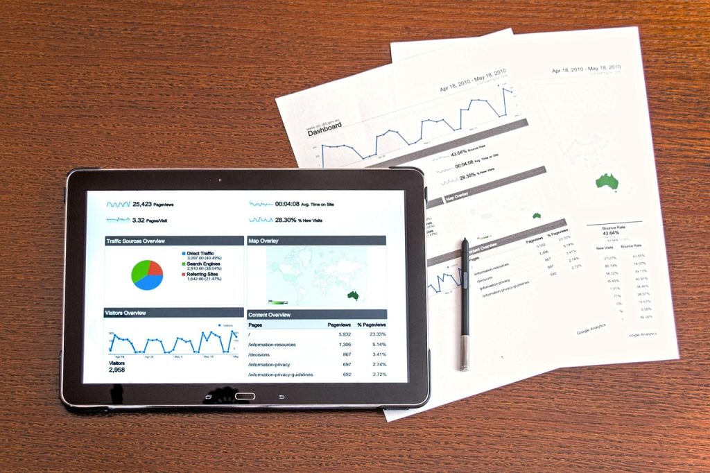 Tablet con dashboard digitale e report cartacei di analisi dati su un tavolo di lavoro