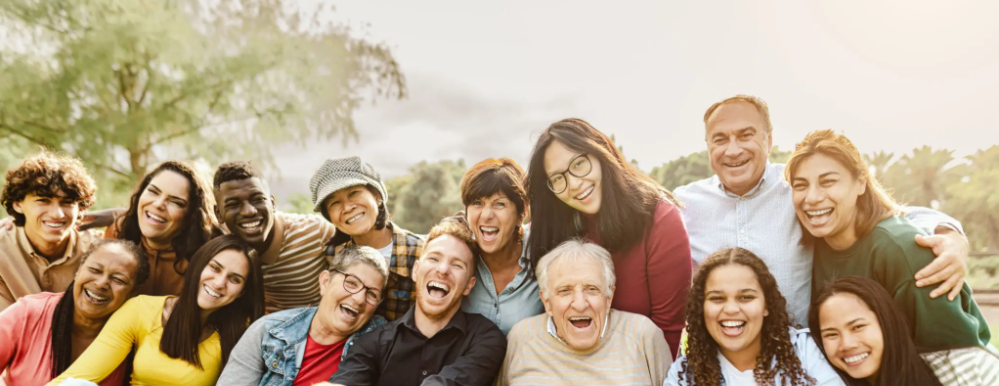 Gruppo multigenerazionale di persone che ridono insieme, rappresentazione delle diverse fasce d’età potenzialmente coinvolte nei rischi delle companion app