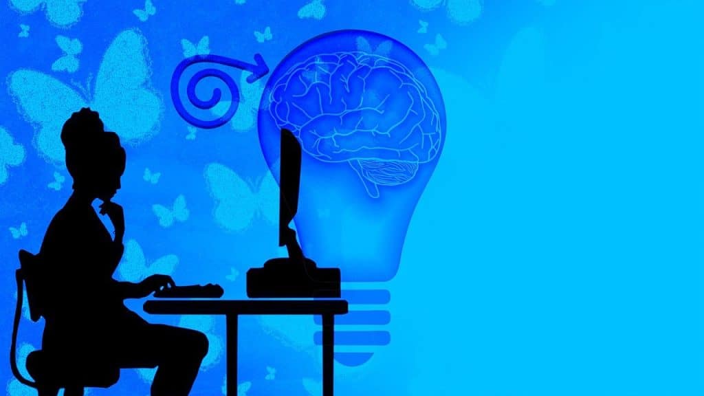 Illustrazione concettuale di una donna al computer con una lampadina raffigurante un cervello, simbolo di pensiero critico e consapevolezza nell’uso dell’intelligenza artificiale