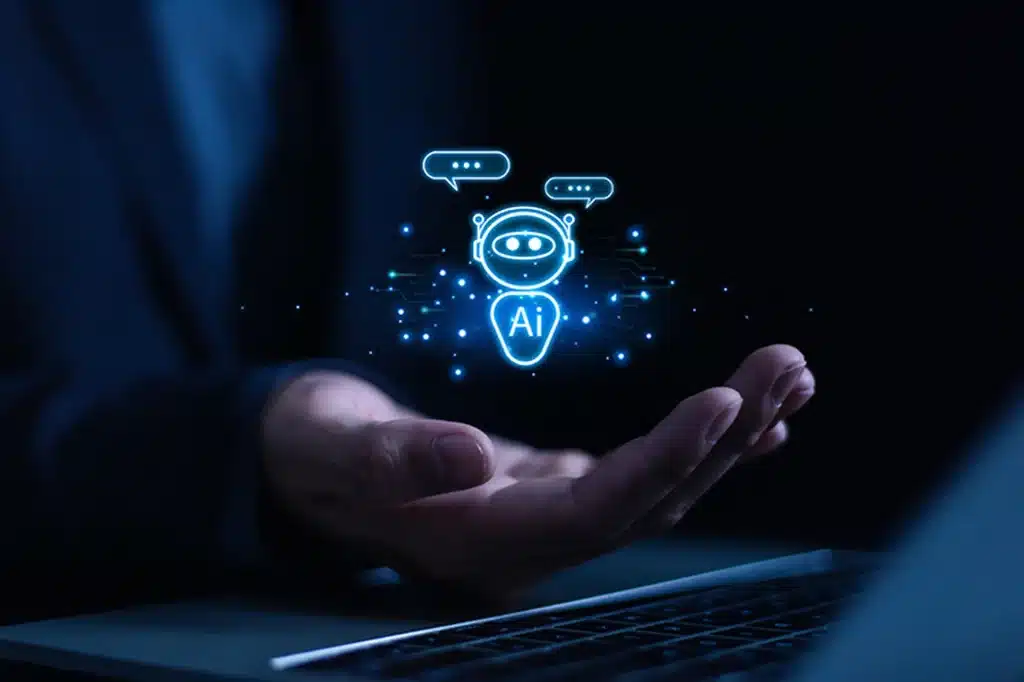 Mano davanti a un laptop con icona di assistente AI luminosa, simbolo della fiducia nell’AI che può amplificare il phishing